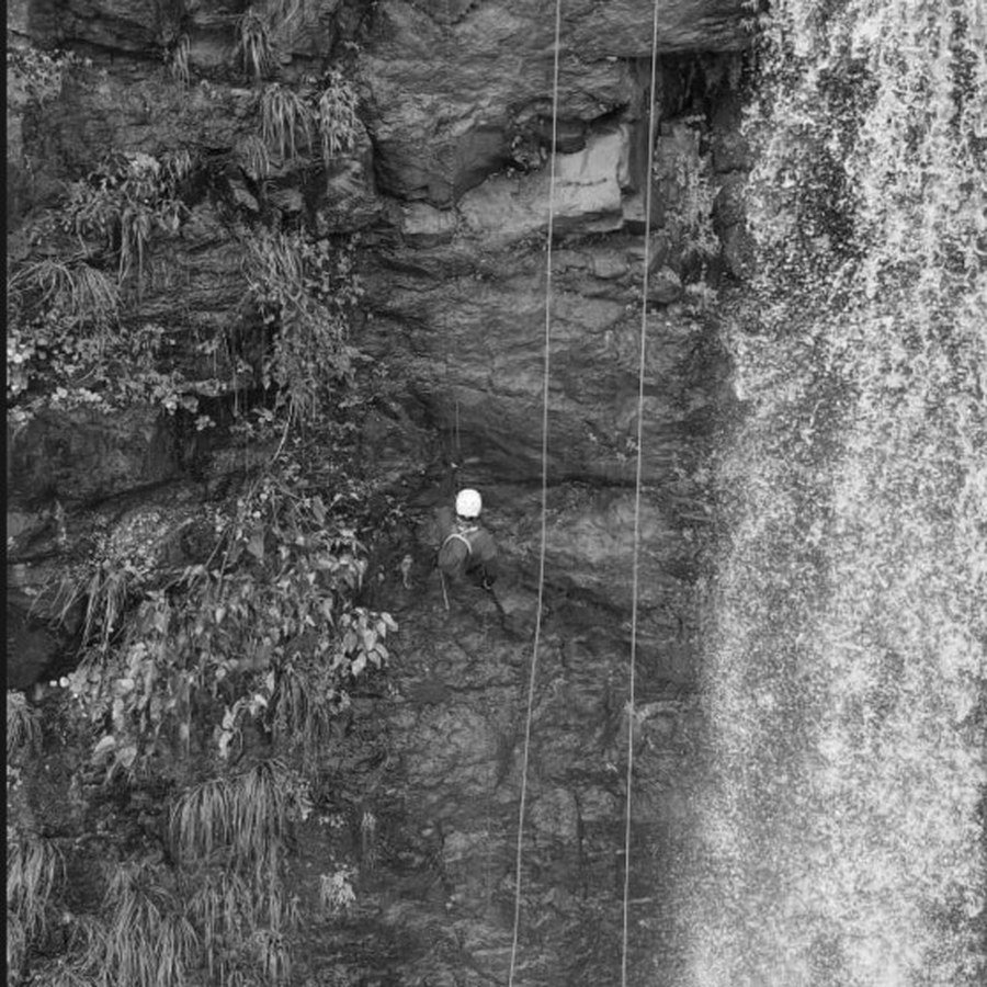 Rappelling beside a waterfall